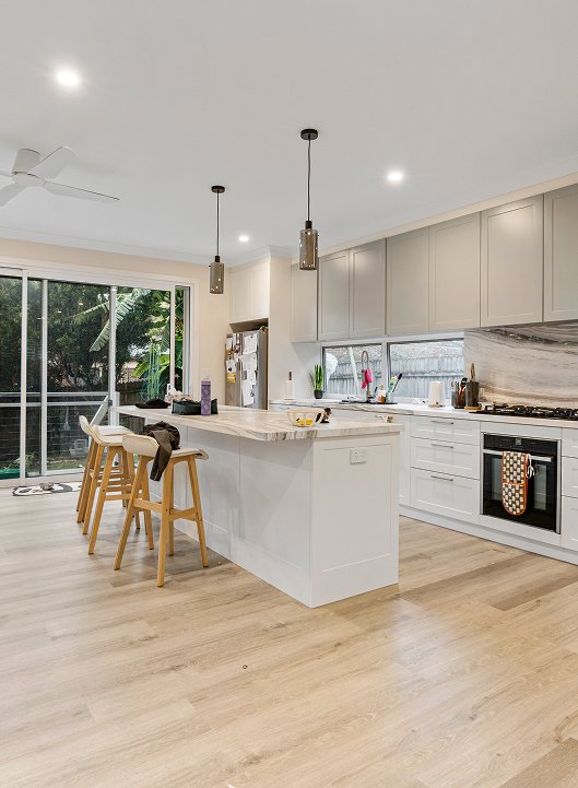 Modern kitchen with pendant lighting over a stone island benchtop