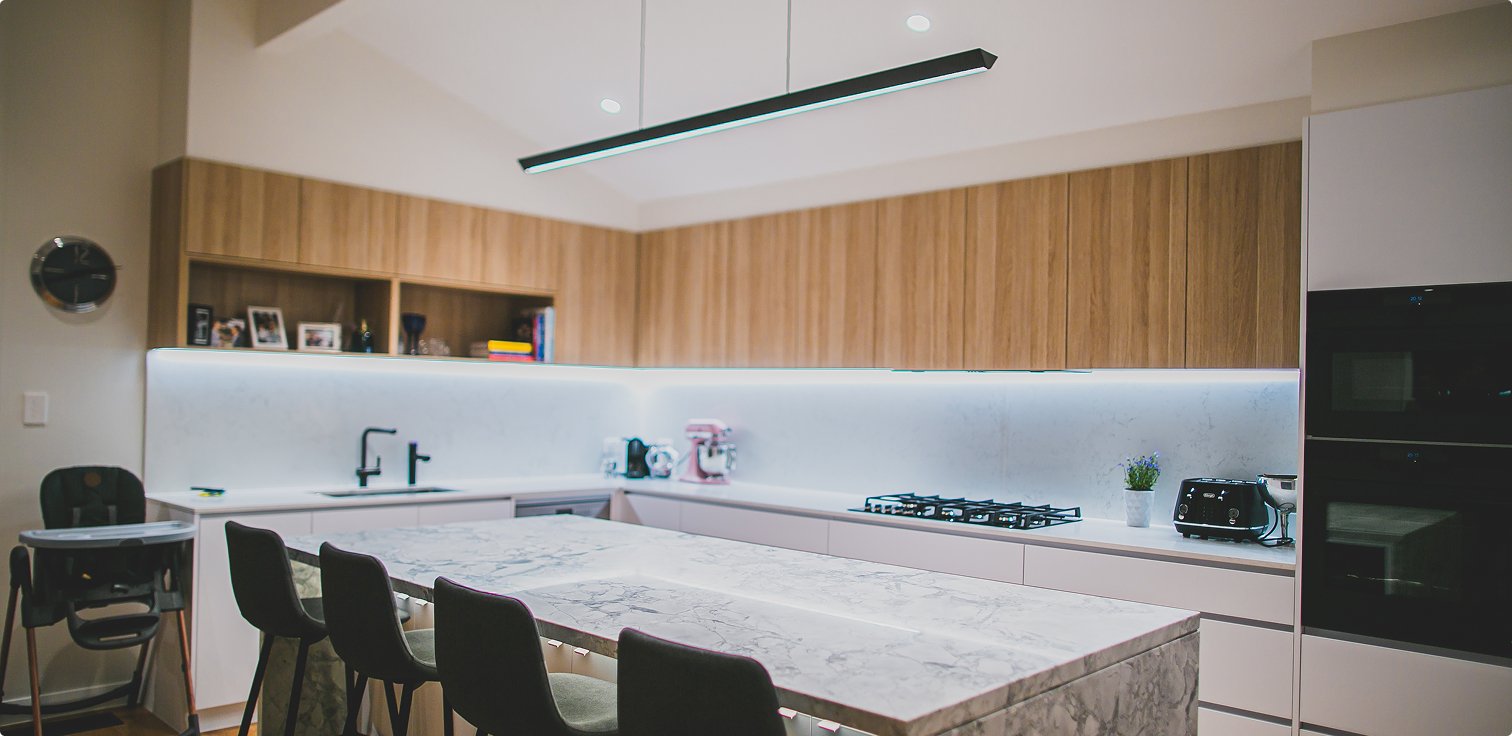 Modern kitchen with wood-panelled cabinetry and integrated lighting