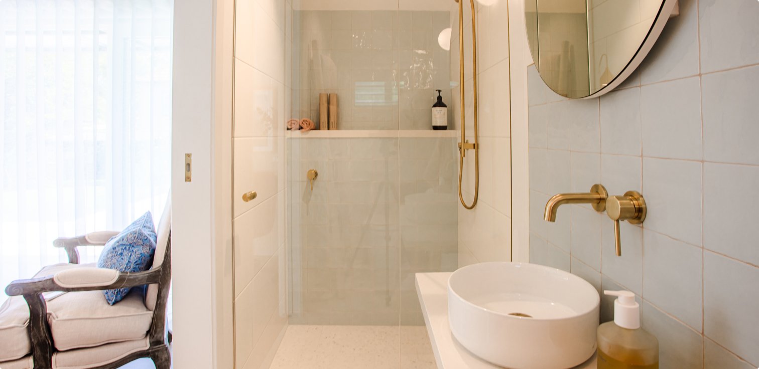 Bathroom shower area with warm lighting and glass panelling